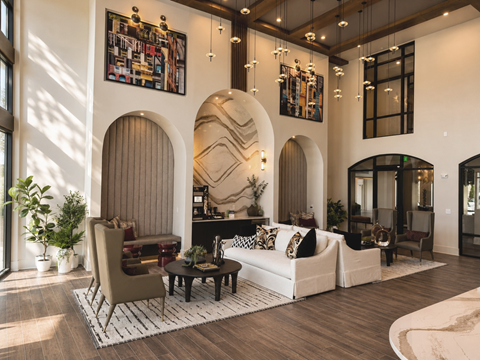 A living room with a white couch, a brown chair, and a coffee table.