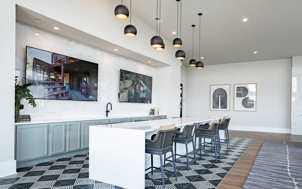 a communal table and chairs in a large room with white walls and a white counter