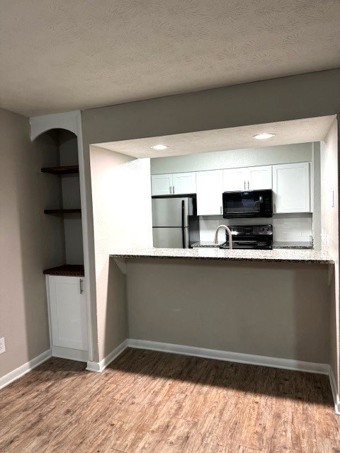 A kitchen area with a microwave, oven, and cabinets.