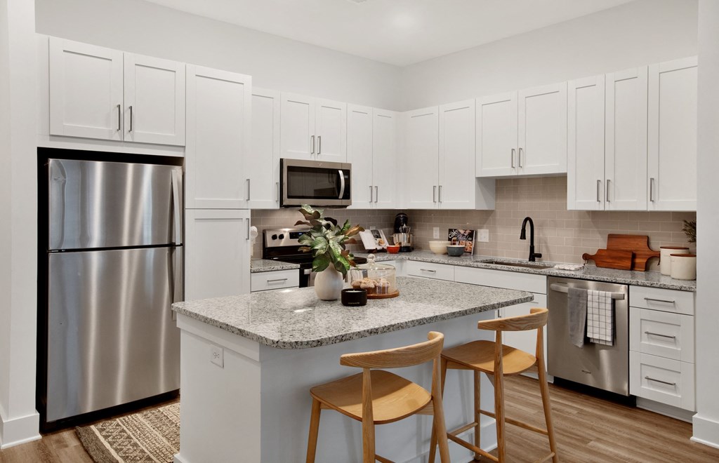 a kitchen with a large island with two stools in front of it