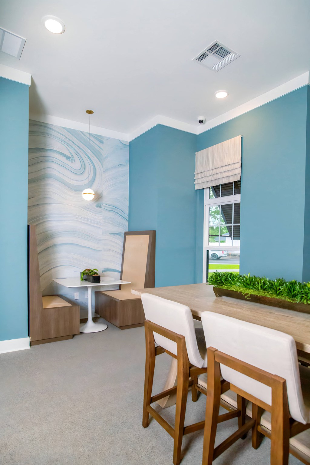 a dining room with blue walls and a table and chairs