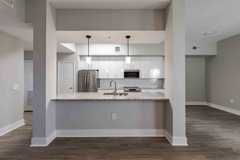A kitchen with a sink and a refrigerator.