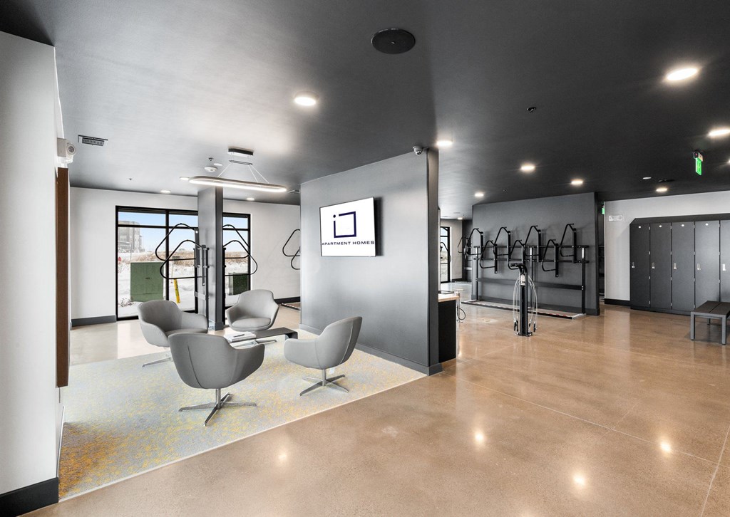 A modern living room with a grey sofa and a white wall.