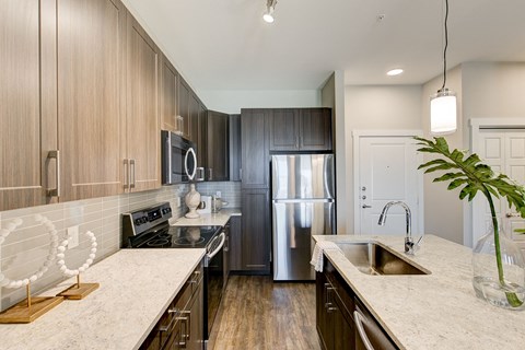 a kitchen with wooden cabinets and a stainless steel refrigerator
