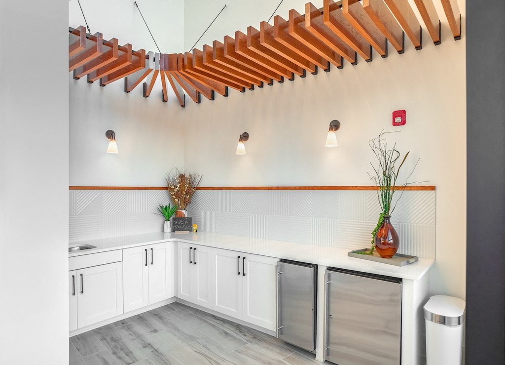 a laundry room with white cabinets and stainless steel washers and dryers