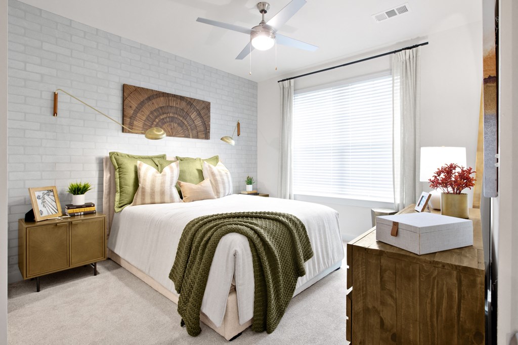 a bedroom with a white bedspread and green pillows