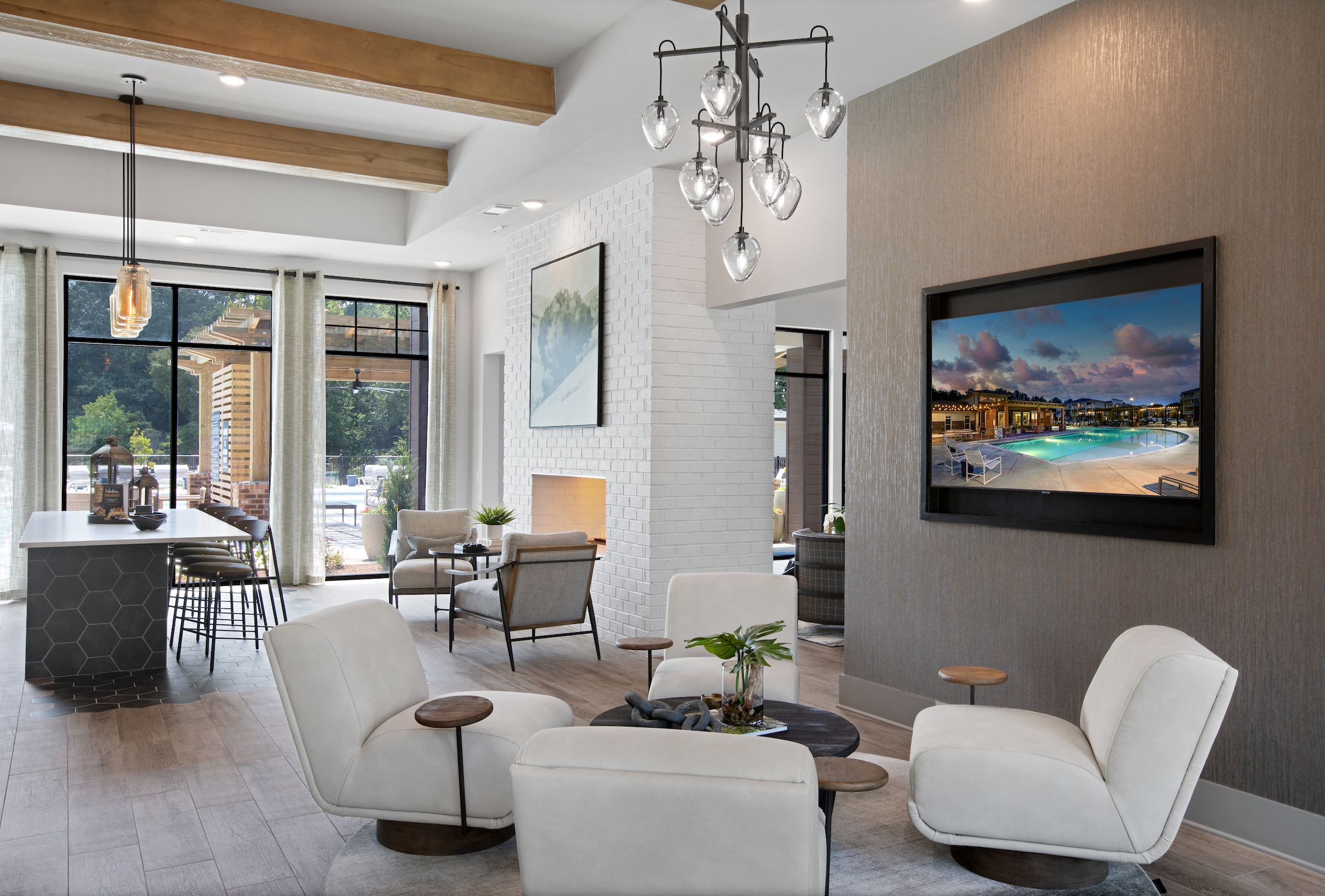 a living room with white furniture and a tv on the wall