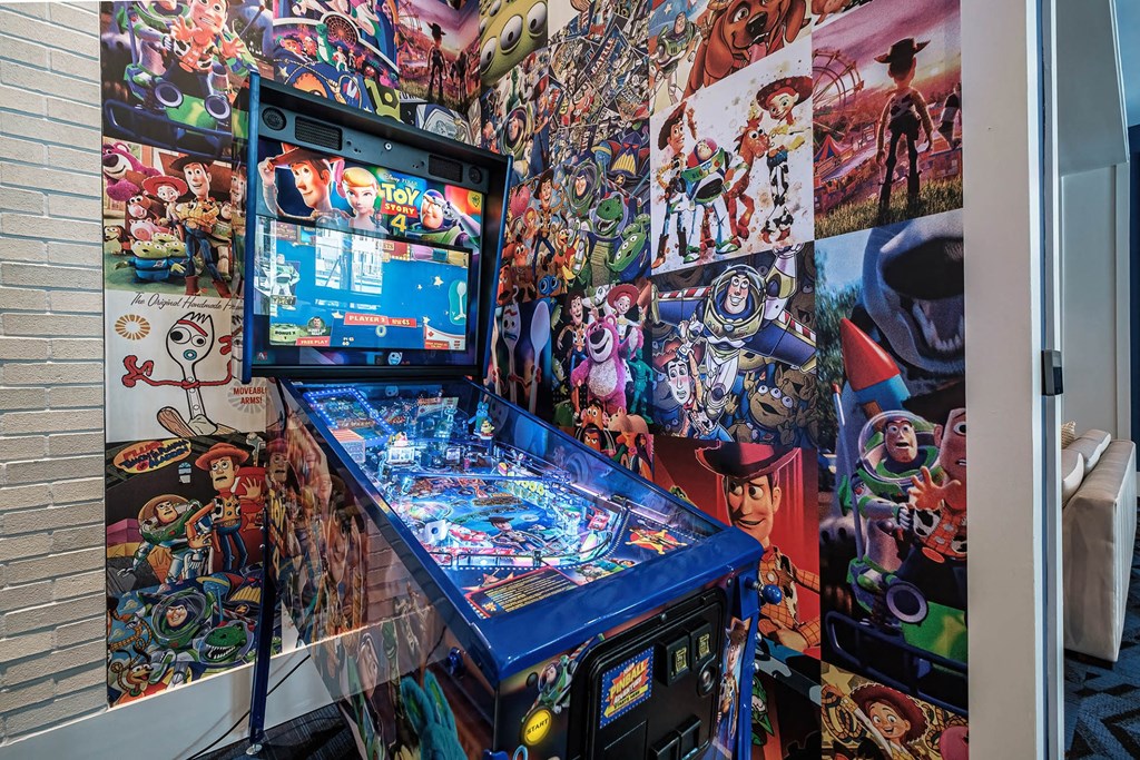 a pinball machine in front of a wall covered in anime pictures