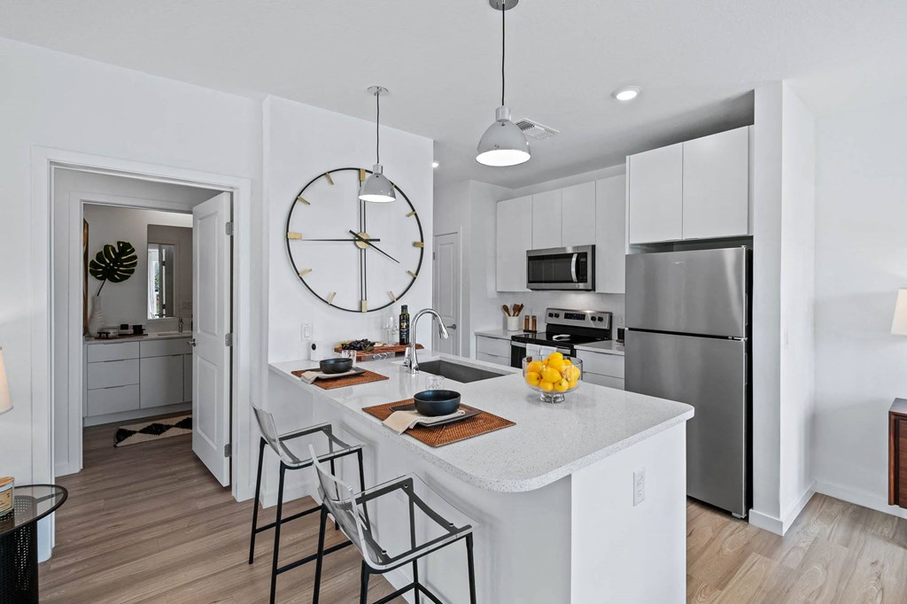 an open kitchen with a large clock on the wall