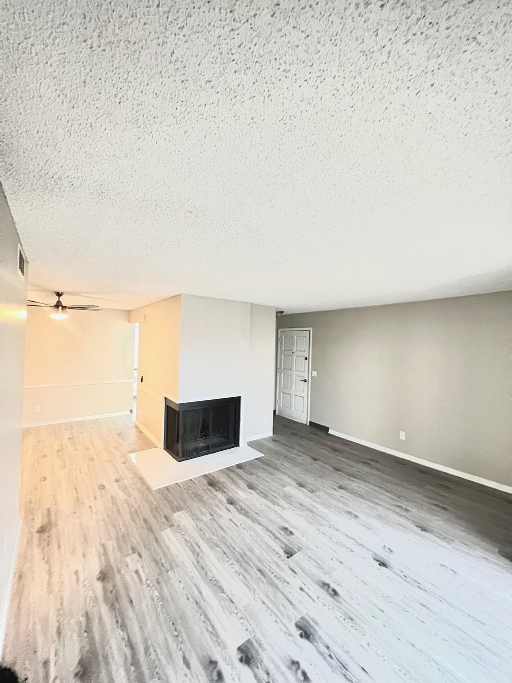 an empty living room with wood floors and a fireplace