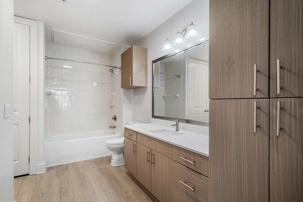 A bathroom with a toilet, sink, and mirror.