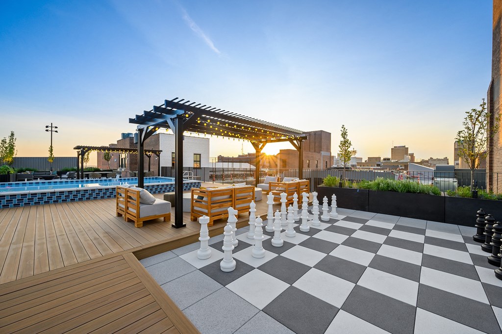 a giant chess board on the rooftop of a building with a cityscape in the background