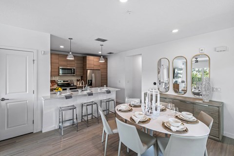 A modern kitchen with a dining table set for four.