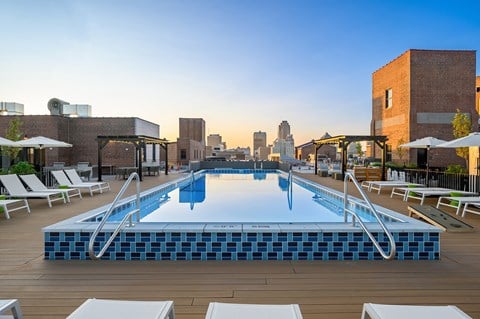 a rooftop pool with a city skyline in the background