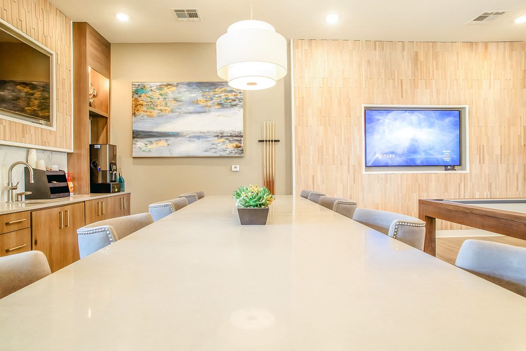 a long white table in a conference room with chairs