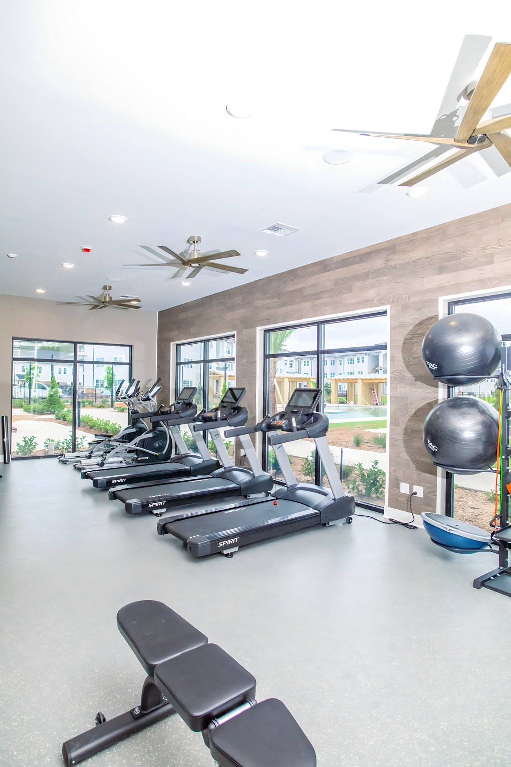 a gym with treadmills and other exercise equipment and windows
