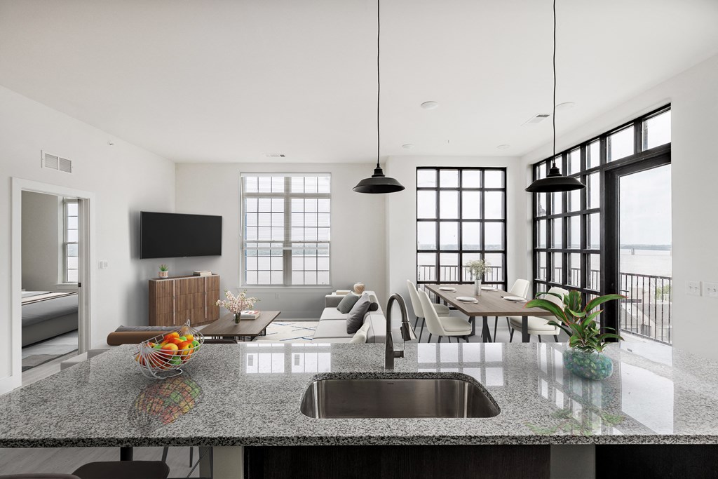 an open kitchen and living room with a granite counter top