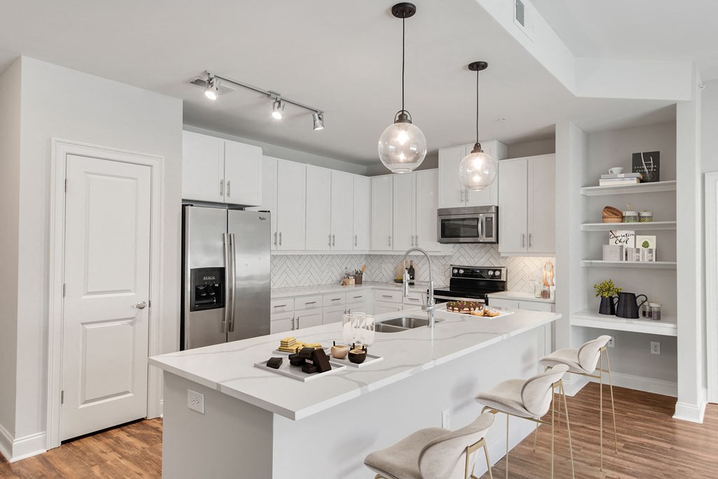2-Bedroom Luxury Apartments In Buckhead, GA - 92 West Paces - Kitchen With White Quartz Counter Tops, Whirlpool Energy Star Stainless Steel Appliances With Ice And Filtered Water Dispenser, White Cabinets, Kitchen Island, Bruce Springdale Gunstock Hardwood Flooring, And A Pantry.