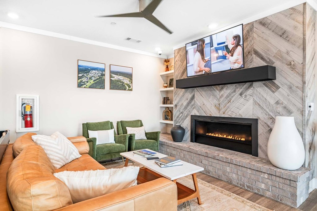 A living room with a fireplace and a television mounted above it.