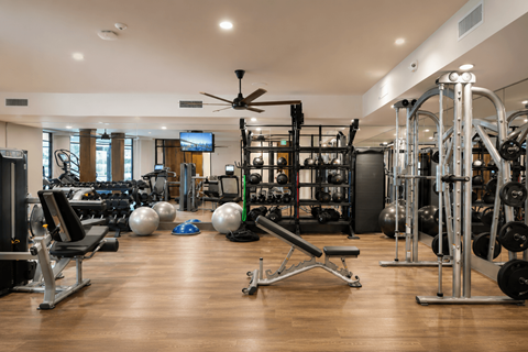 A spacious gym with a variety of equipment and a television.