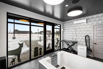 A bathroom with a large mirror and a dog silhouette on the window.