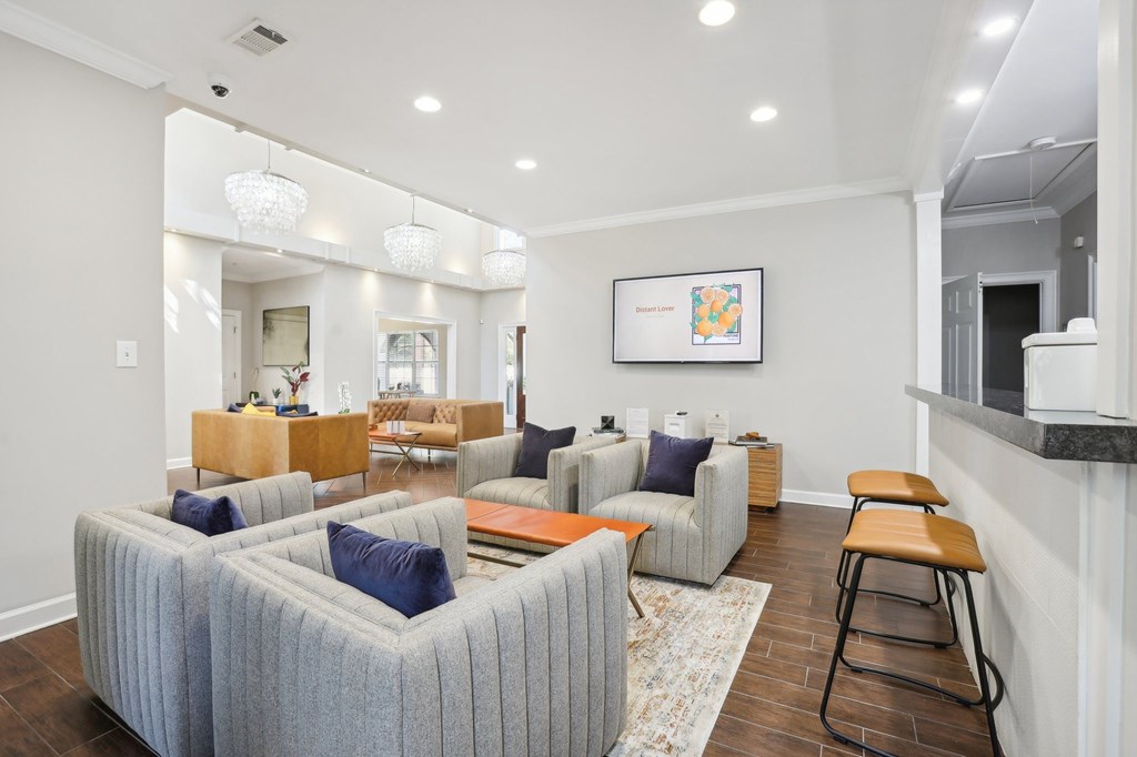 A living room with a grey couch and a wooden stool.
