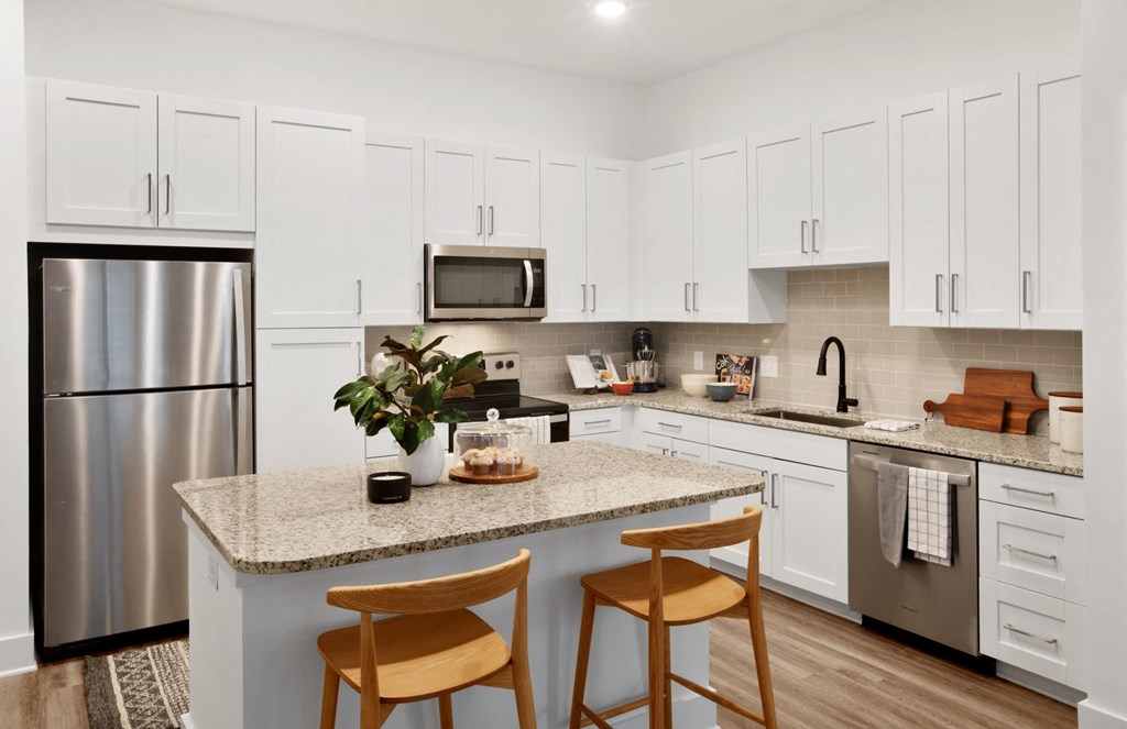 a kitchen with a large island with two stools in front of it