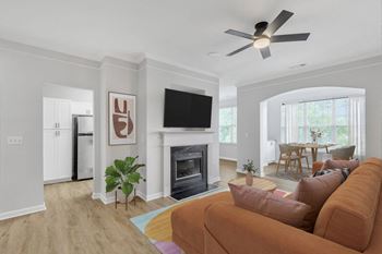 A living room with a brown couch and a fireplace.