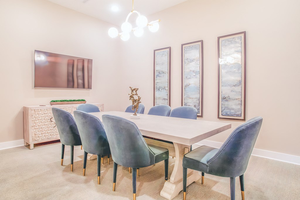 a dining room with a long table and blue chairs