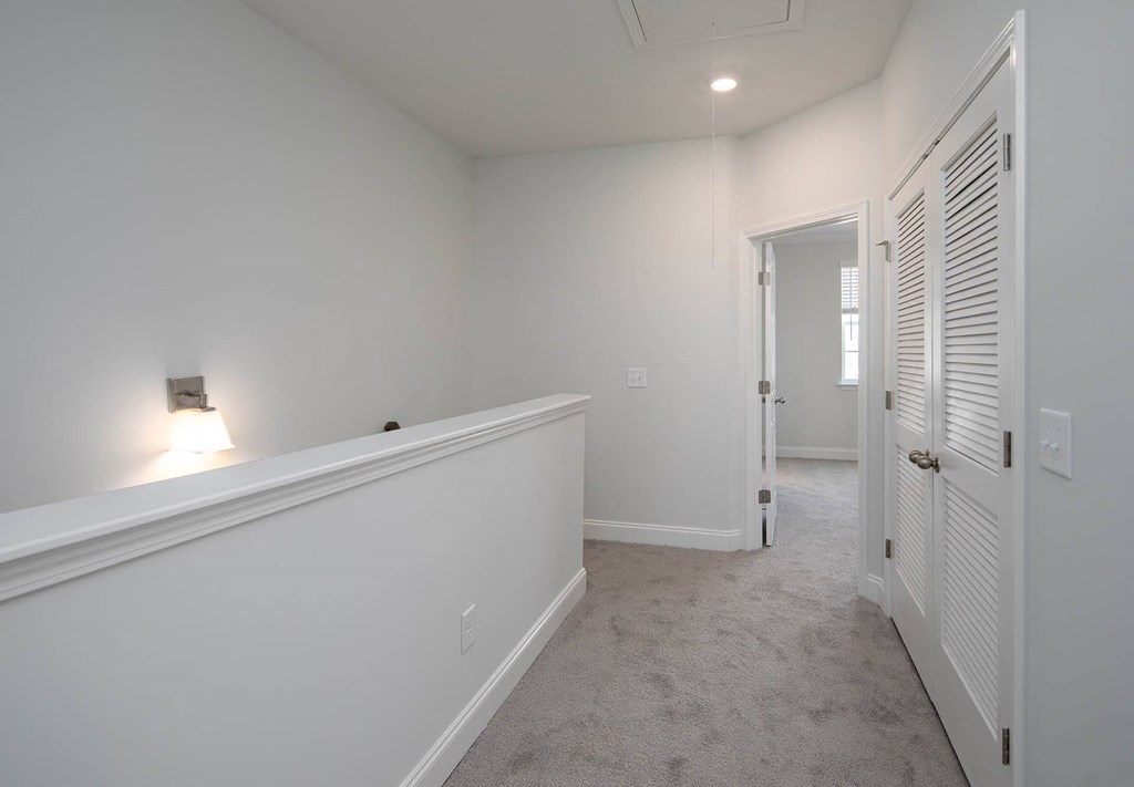 a bedroom with a medium sized bed and a doorway into a room