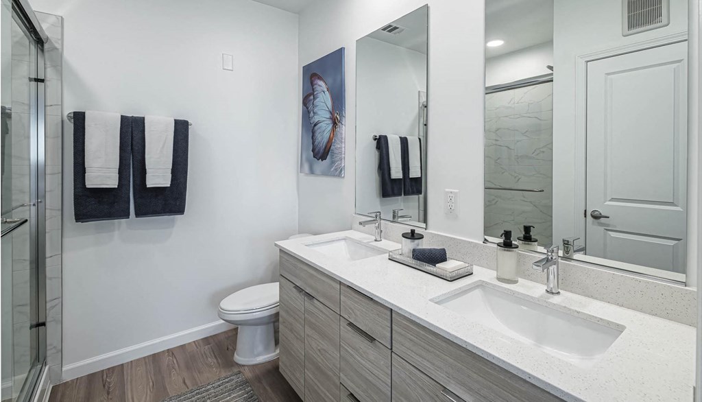 a bathroom with two sinks and a shower and a toilet