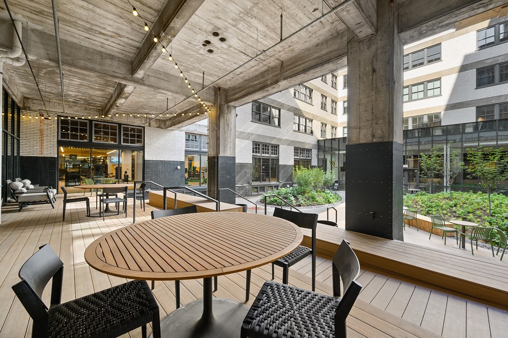 a large patio with a wooden table and chairs