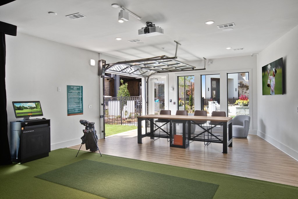 a tv and a table with chairs in a room with white walls and wood floors