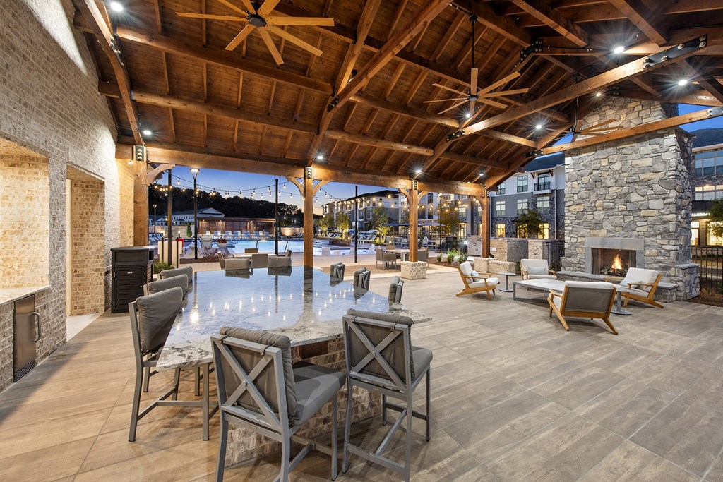 a large patio with a table and chairs and a fireplace