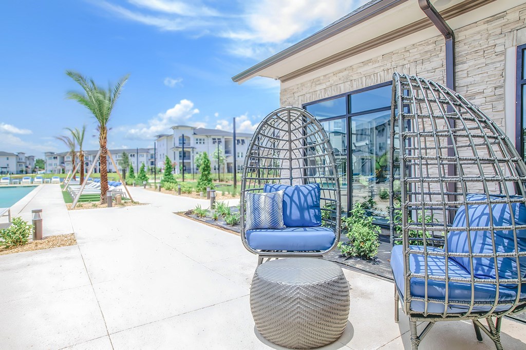 a patio with chairs and a table and a pool