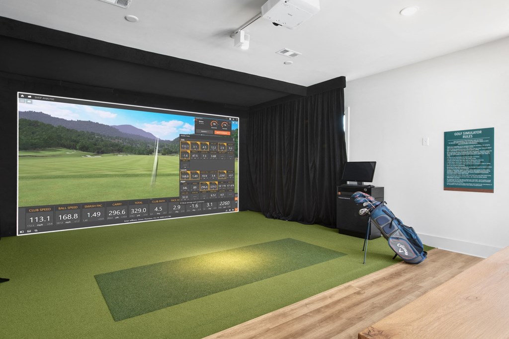a golf simulator with a large screen on the wall