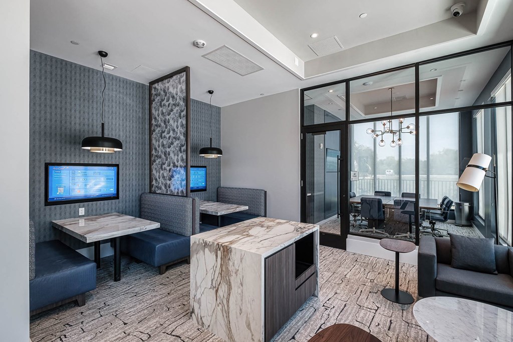 a lobby with couches and tables and a tv