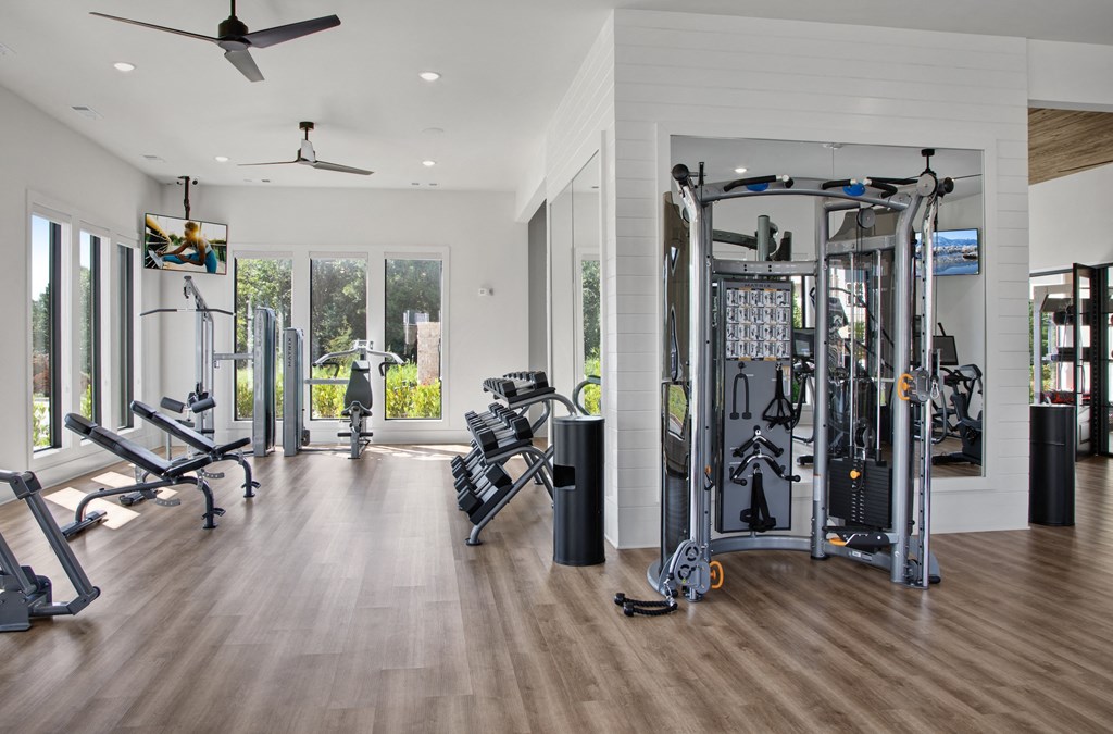 a home gym with exercise equipment and a large window