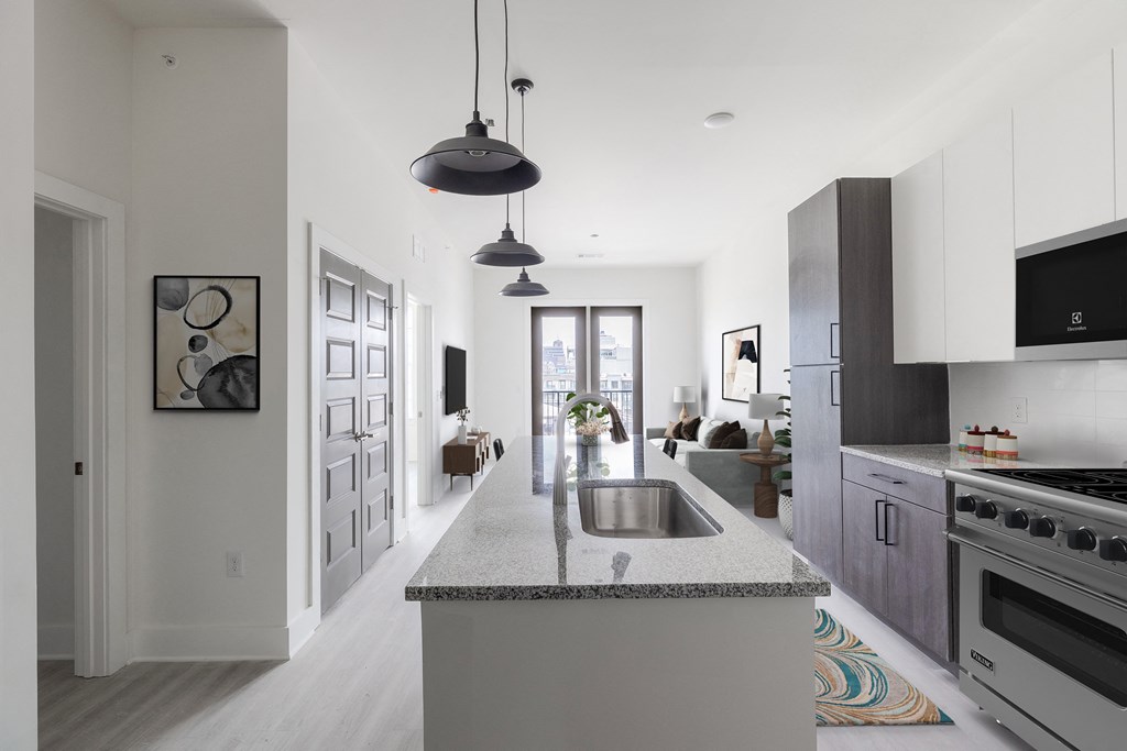 a kitchen with an island and a sink and a living room