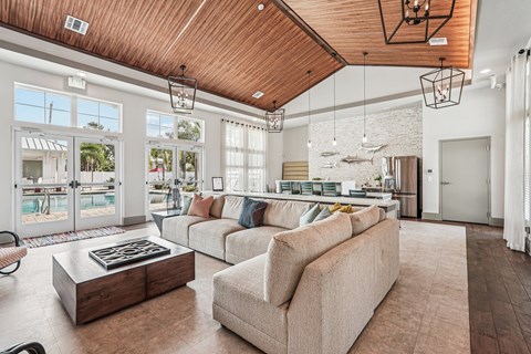 A living room with a wooden ceiling and a large window.