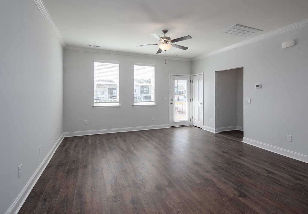 a bedroom with a ceiling fan and three windows