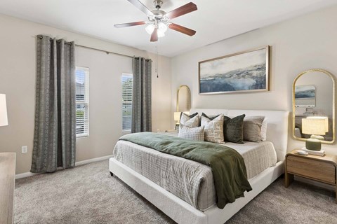 A bedroom with a large bed and a ceiling fan.