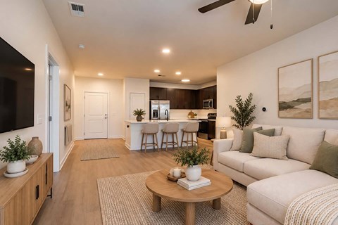 A living room with a white couch, a wooden coffee table, and a ceiling fan.