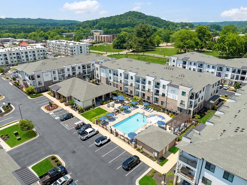 A large apartment complex with a swimming pool and a parking lot.