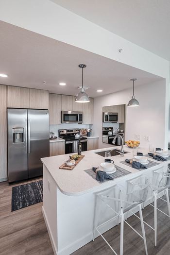 a kitchen with a large island and stainless steel appliances  Altis Santa Barbara, Naples, FL