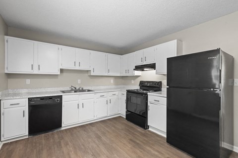 a kitchen with white cabinets and black appliances