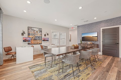 A dining room with a white table and chairs.