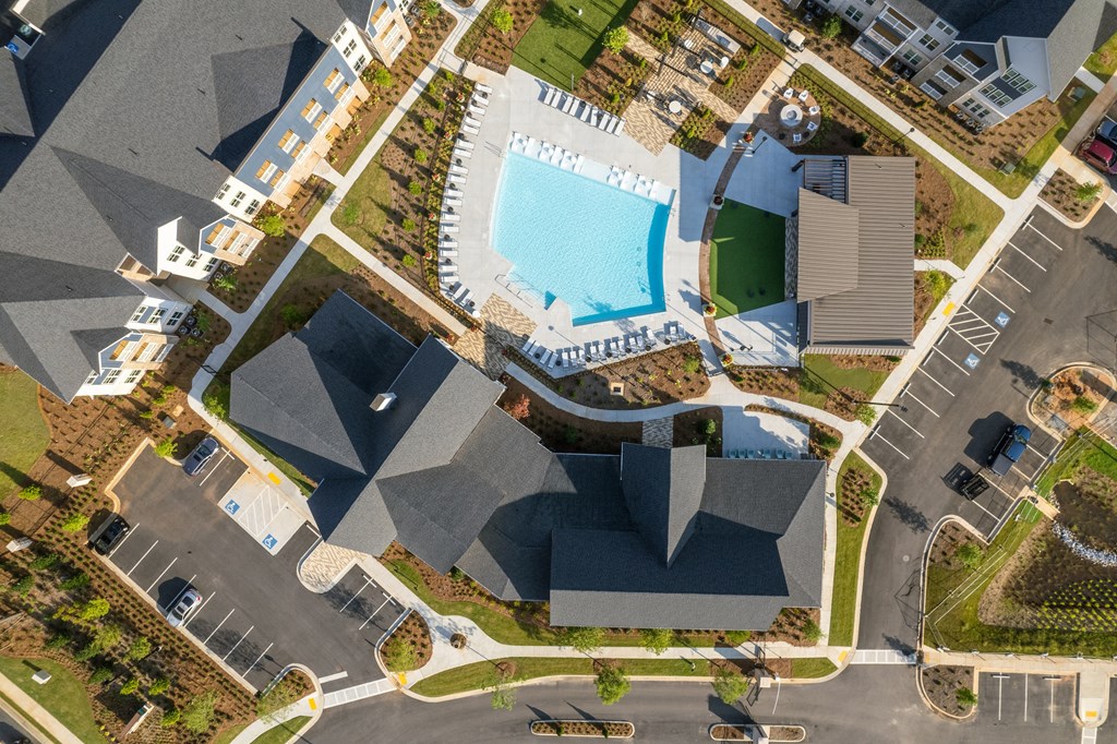 an aerial view of a resort property with a swimming pool and parking lot