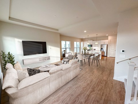 a living room and dining room with a couch and a tv