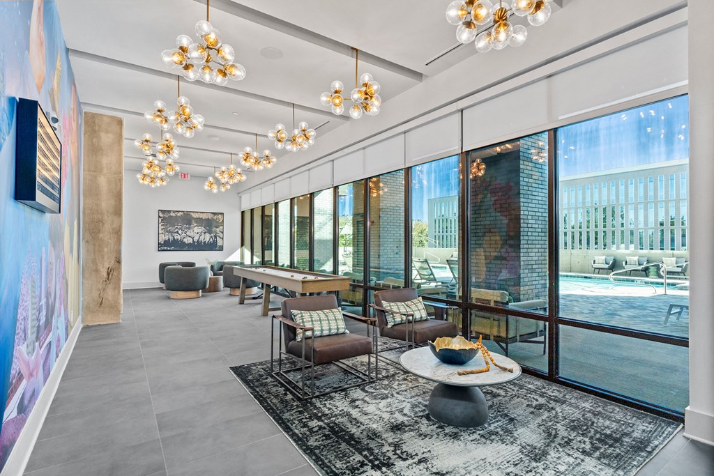 A living room with a large window and a view of a pool.